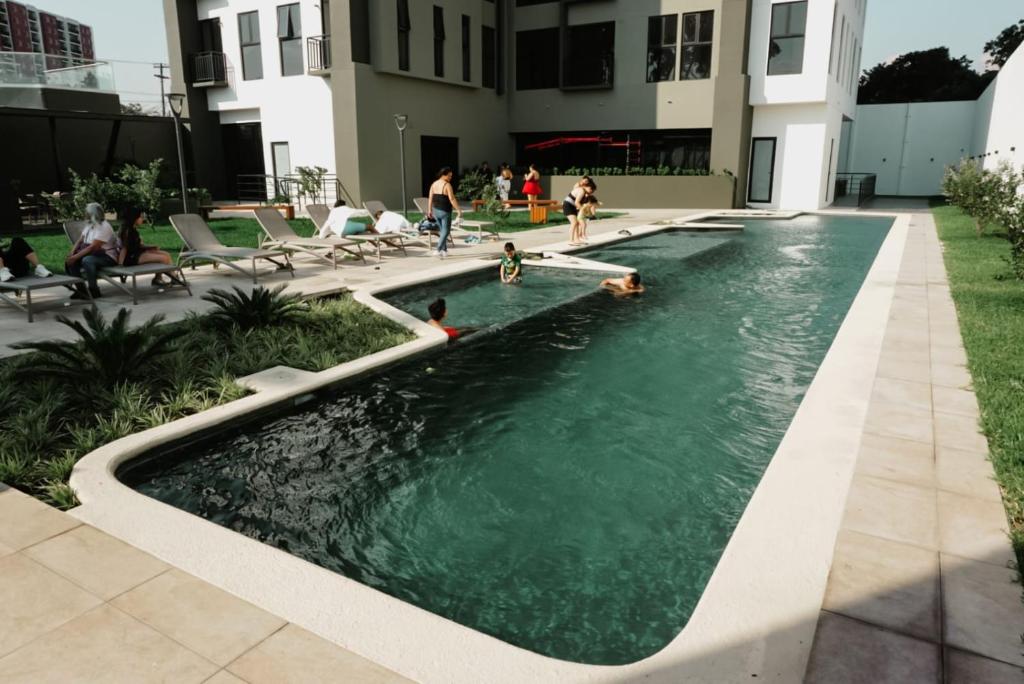 a swimming pool with people playing in the water at Luxury Skyline Apartment with pool, city views & volcano views in El Rodeo