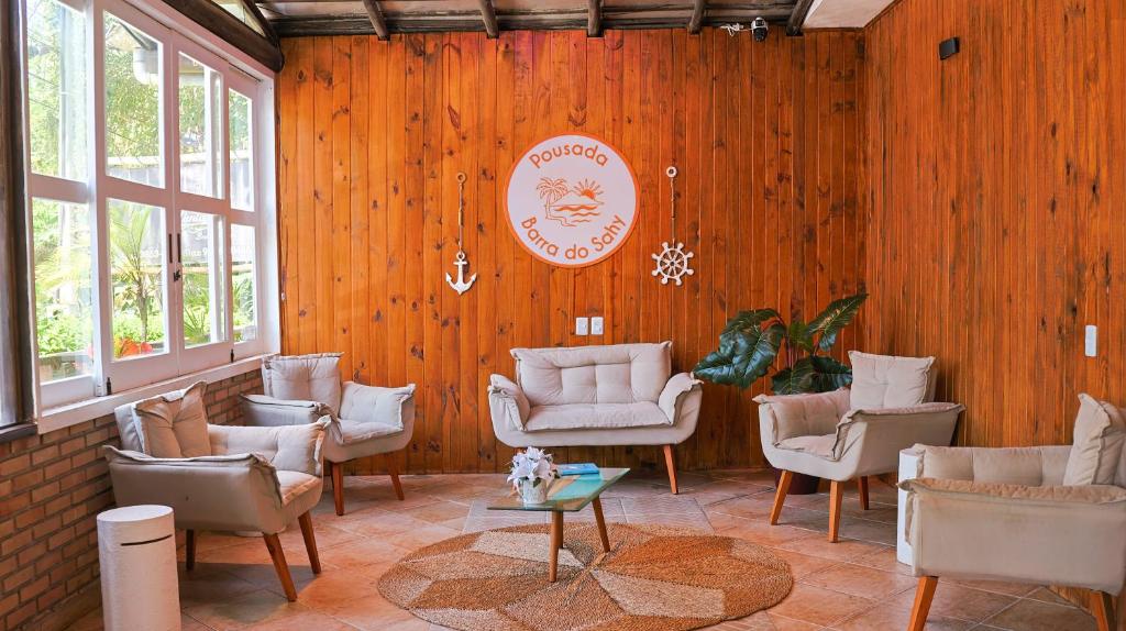 a room with a bunch of chairs and a table at Pousada Barra do Sahy in Barra do Sahy
