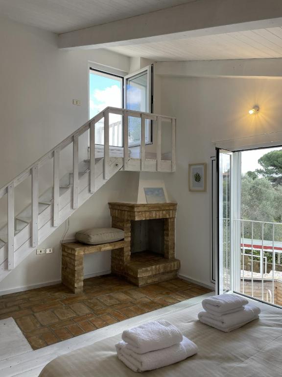 a living room with a staircase and a fireplace at Casa Collina - Grottino in Pisticci