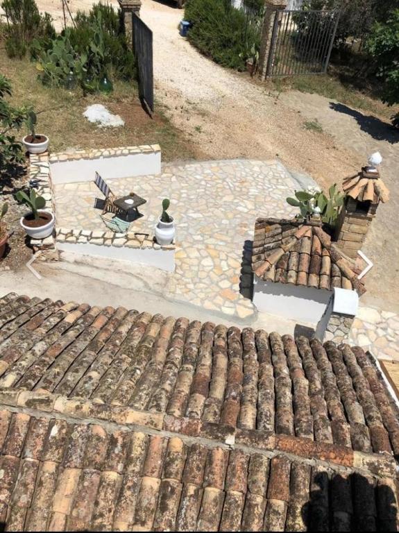 a backyard with a stone patio with plants and a fence at Casa Collina - Isola in Pisticci