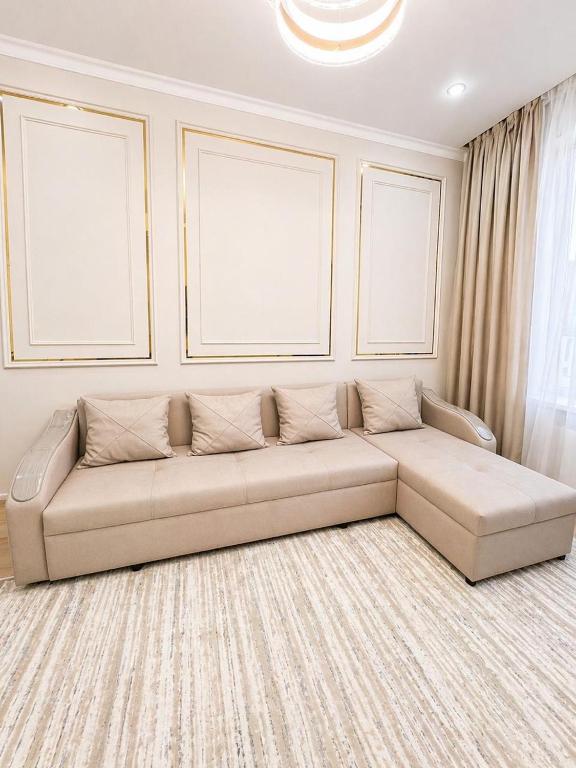a living room with a couch in a room at River City Luxe Appointment in Almaty