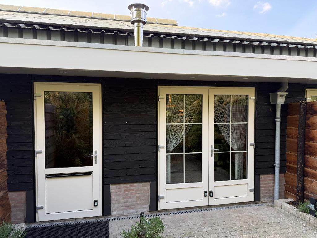 a black house with white doors and windows at 't Woldhoesie in Diever
