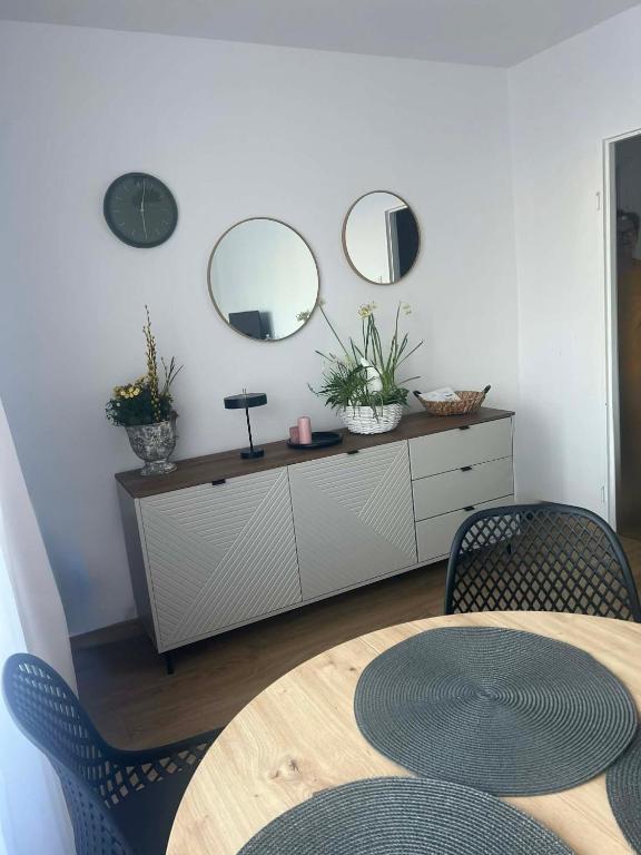 a dining room with a table and two mirrors at Apartament Blue Velvet in Skierniewice