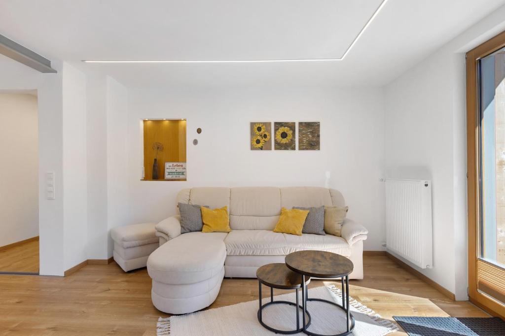 a white living room with a couch and a table at Ferienwohnung am Brändbach in Bräunlingen