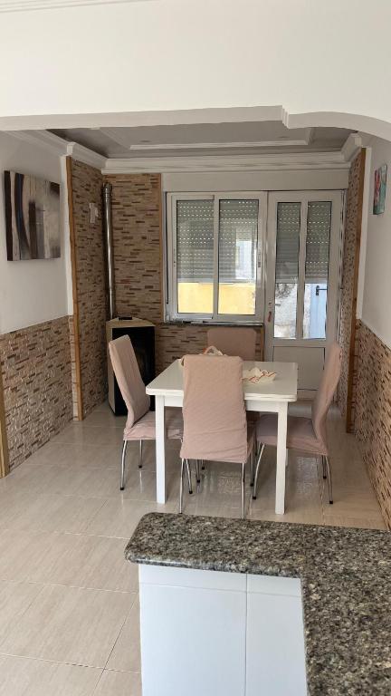 a dining room with a table and chairs and windows at Ana in Burela de Cabo