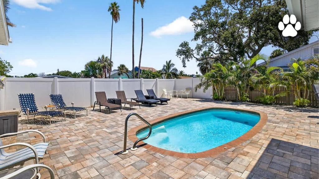 a swimming pool in a patio with chairs and a fence at Buffalo Bungalow in Clearwater Beach