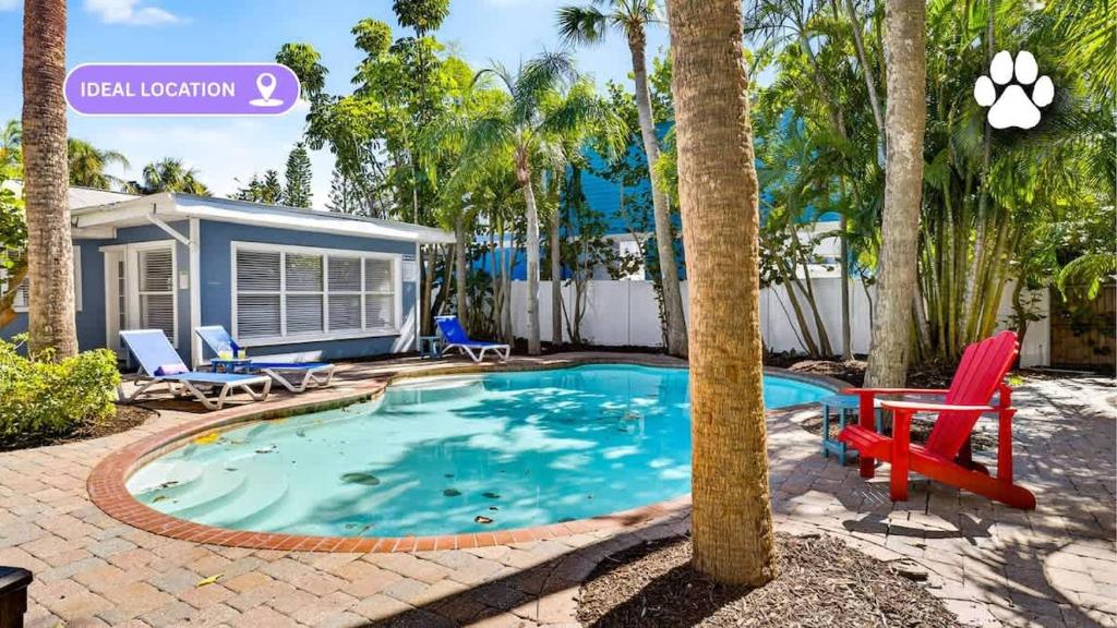 a swimming pool with a red chair and a house at Lantana Cabana in Clearwater Beach