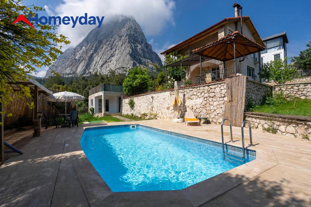 a villa with a swimming pool in front of a mountain at Villa Mountain with Pool in Gedeller