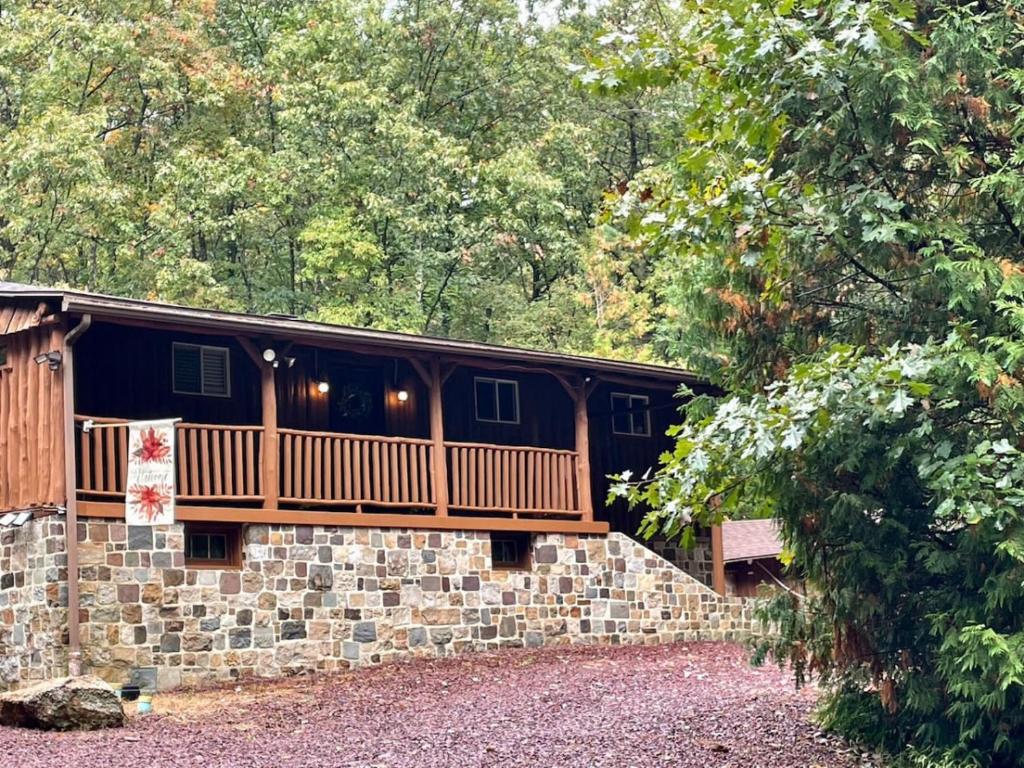a house with a deck on top of a stone wall at Cozy Log Cabin in Jim Thorpe in Jim Thorpe