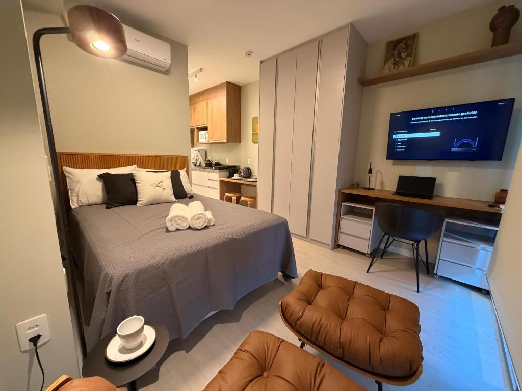 a bedroom with a bed and a living room at 08 Studio com Arte e Sofisticação perto do Consulado in São Paulo