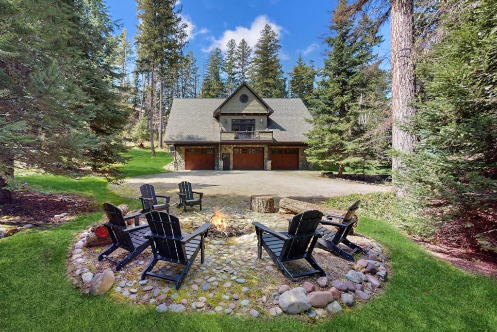 a group of chairs sitting around a fire pit in front of a house at Deer Haven Lodge in Kalispell