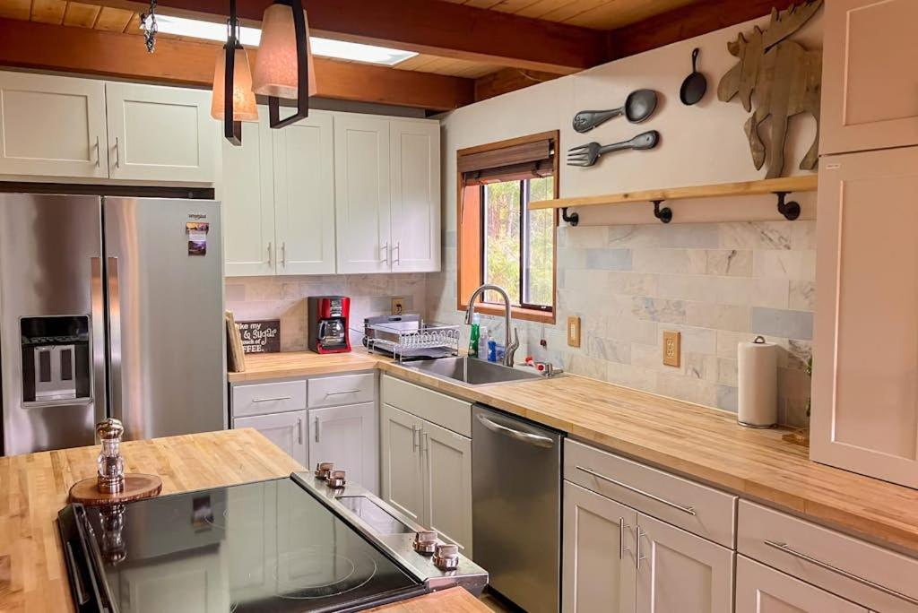 a kitchen with white cabinets and a sink at The Music Chalet in Ronald