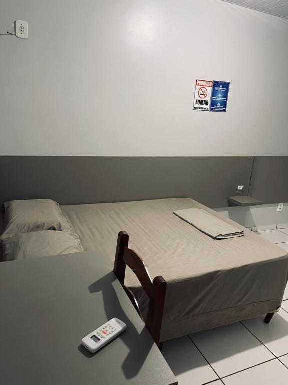 a bed with a remote control sitting on top of it at Hotel Real in Realeza