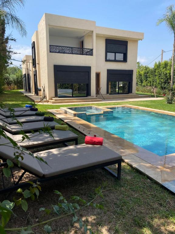 a villa with a swimming pool and lounge chairs at Villa Dar SAYF in Najem