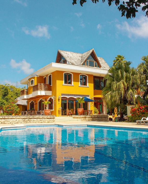 a yellow house with a swimming pool in front of it at Casa Las Palmas in San Andrés