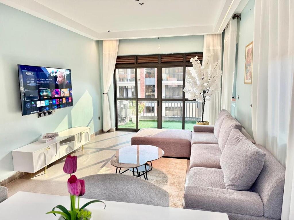 a living room with a couch and a tv at comfort homes in Kampala