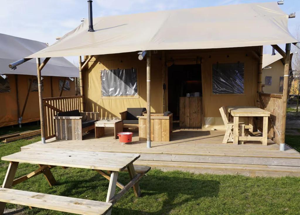 a large tent with a picnic table and benches at F1 Ardennes Stay 5p Parking Bashfull in Amblève