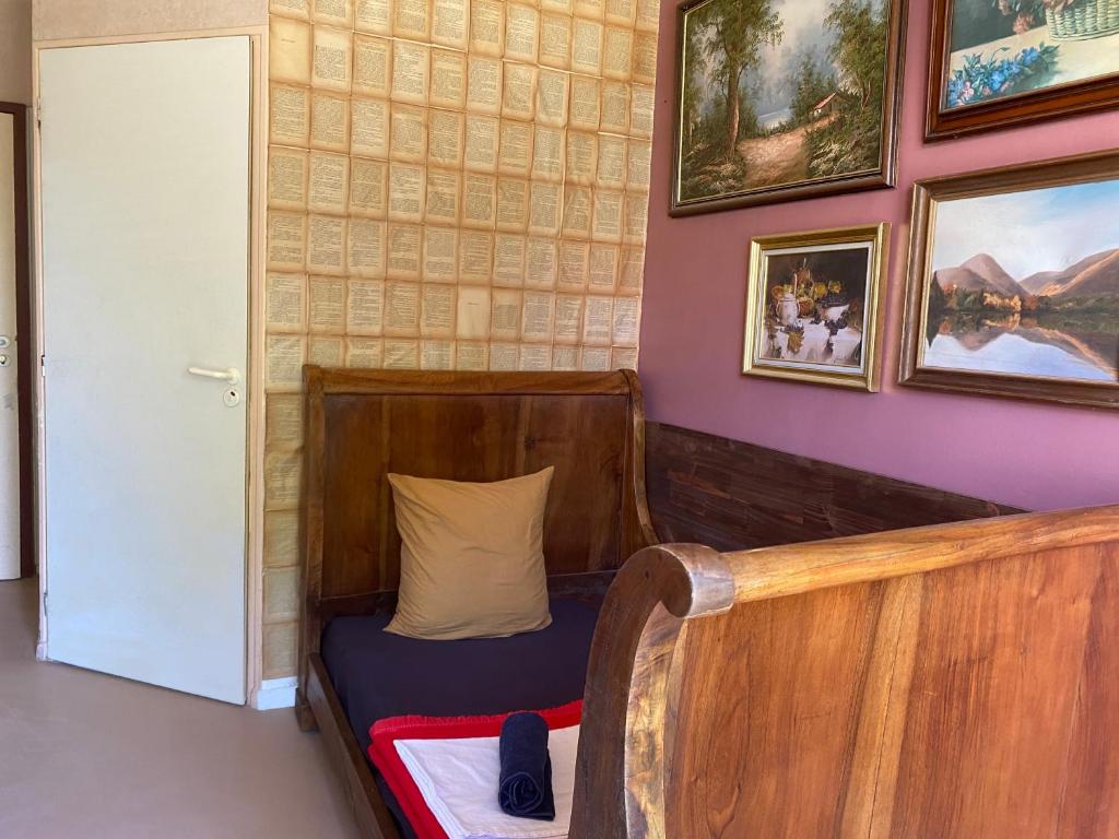 a small bed in a room with paintings on the wall at Evasion Latine in Castelnau-Rivière-Basse