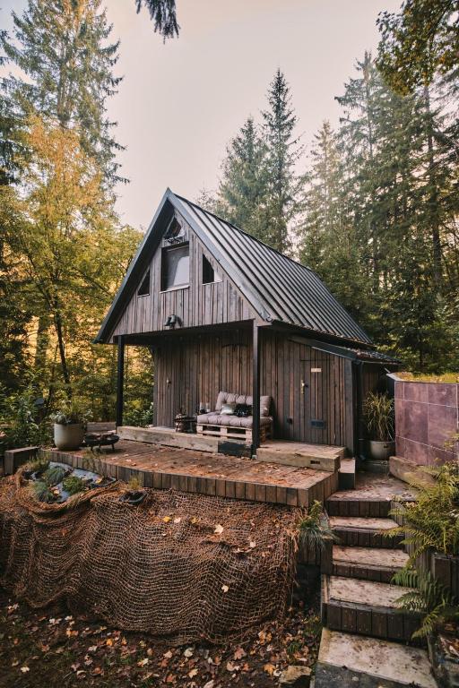 a small wooden cabin with a porch and stairs at OLA I Oáza Les Atmosféra I Oasis Forest Atmosphere in Petrov