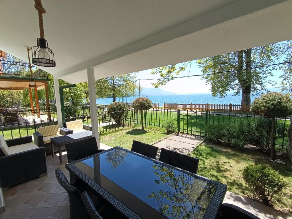 a patio with a table and chairs and a view of the ocean at Villa Paradiso in Ohrid