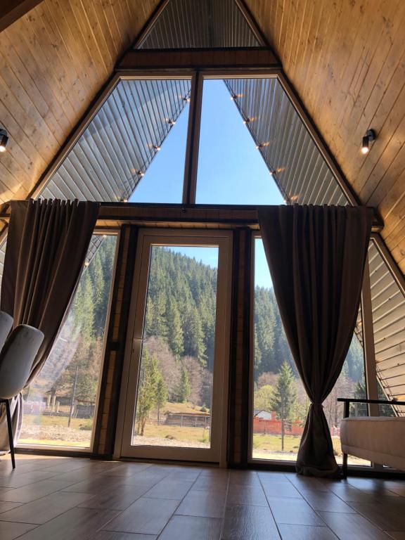 an attic room with a large window with curtains at Frame&Forest2 in Kolochava