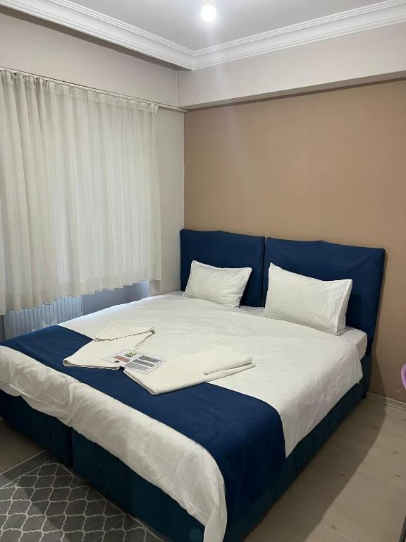 a bed with a blue headboard and a laptop on it at Safranbolu apartments in Karabük
