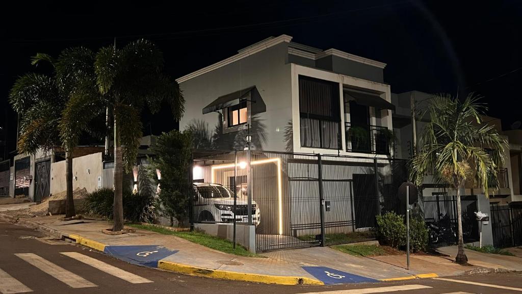 a white house with a truck parked in front of it at Sobrado inteligente, A C, TVs Smart e garagem in Toledo
