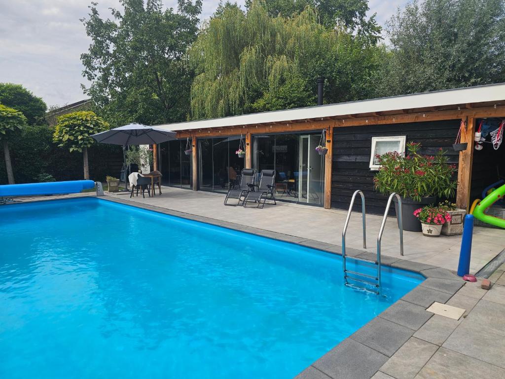 a swimming pool in front of a house at Ham Annex met privé jacuzzi in Almelo