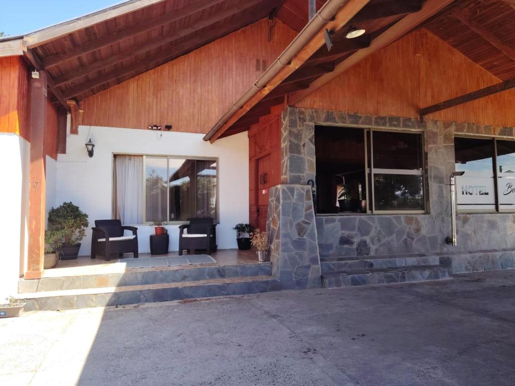 an outdoor patio with chairs and windows on a building at Hospedaje Centro Huequén in Angol