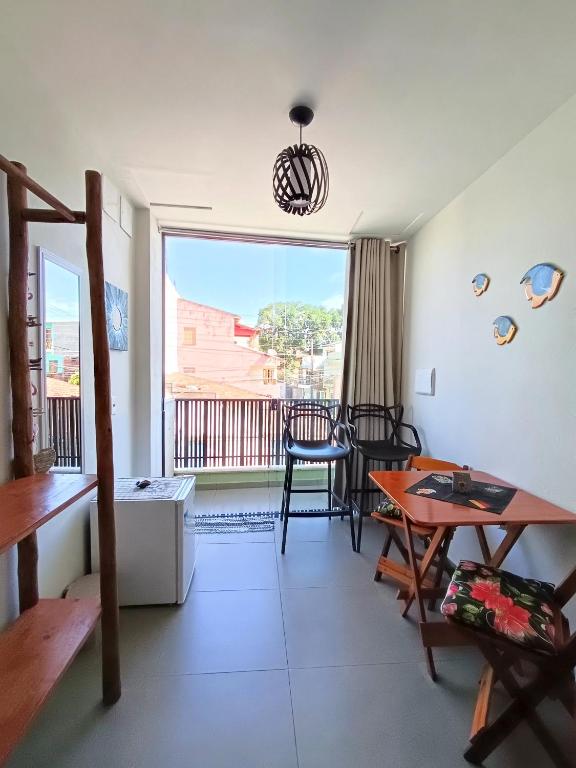 a living room with a table and a balcony at Residencial Lucernaré - Tiririca in Itacaré