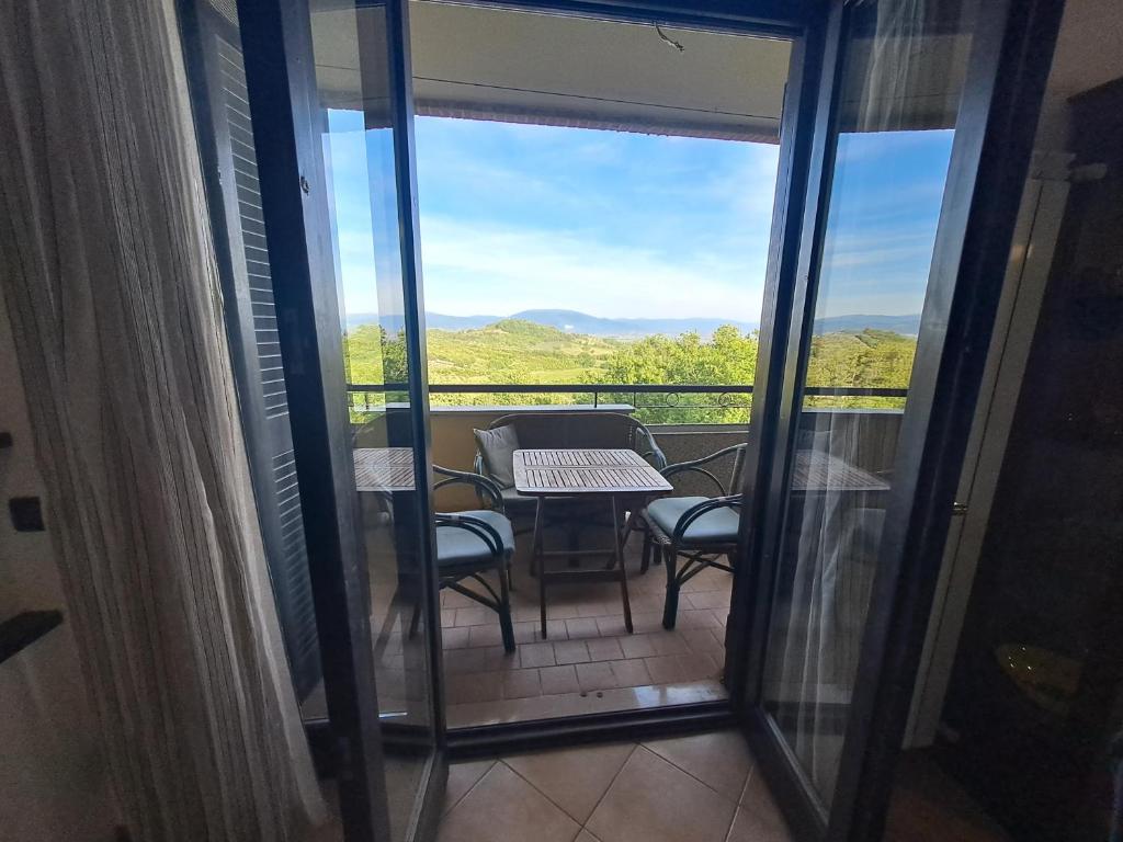 a balcony with a table and chairs and a view at Casa Panorama Assisi in Perugia