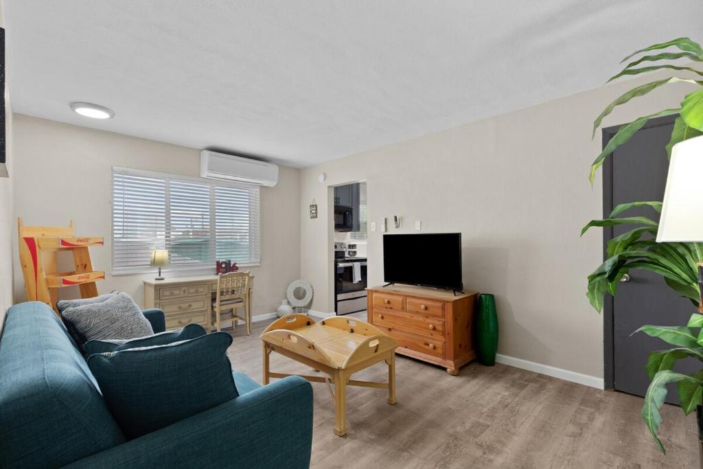 a living room with a blue couch and a tv at Private 1BR for Two on Morganford in Saint Louis