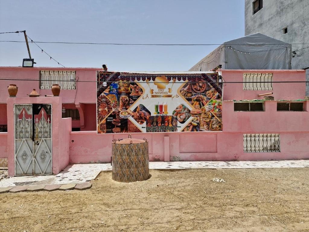a pink building with a mural on the side of it at El khaïma in Saint-Louis