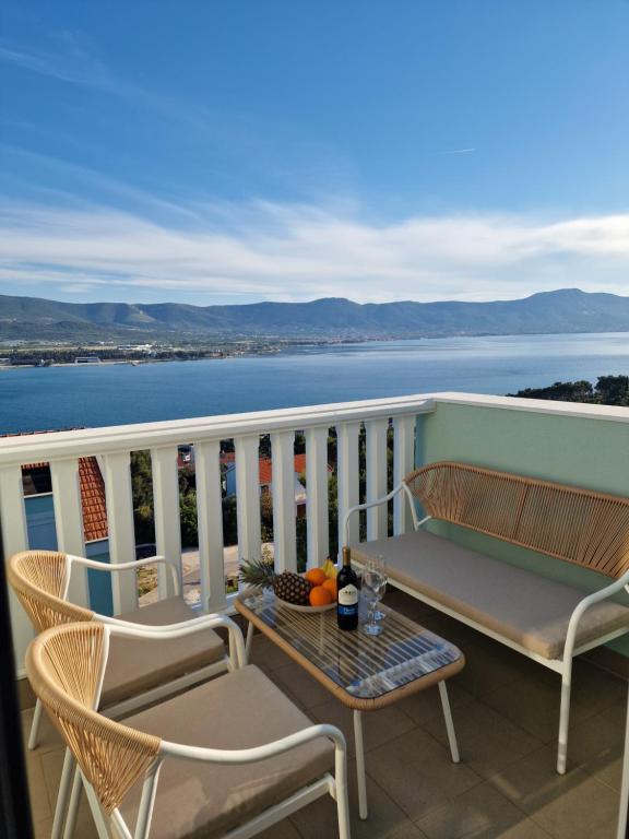 a table and chairs on a balcony with a view of the water at Compass Apartment in Trogir