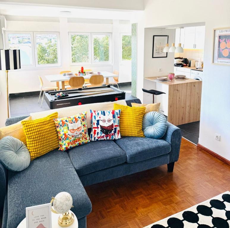 a living room with a blue couch with yellow pillows at Ambassador's Retreat in Oeiras