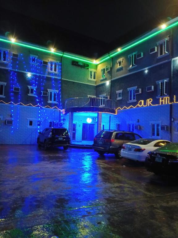 a building with christmas lights in a parking lot at OUR HILLs HOTELs AND SUITES in Ekoro