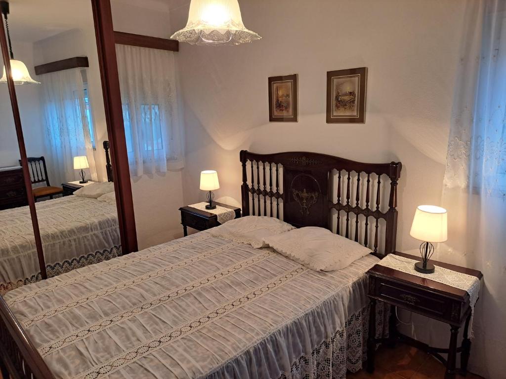 a bedroom with two beds and two lamps and a mirror at Casa da Miquinhas I in Ponte da Barca