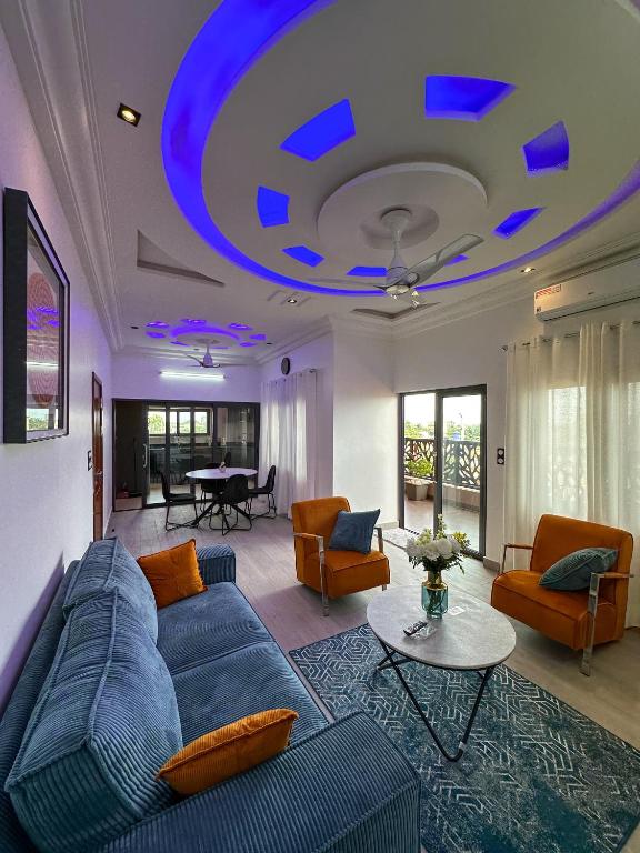 a living room with a blue couch and a table at Les Résidences AKATA-Appartement HOUÈ in Abomey-Calavi