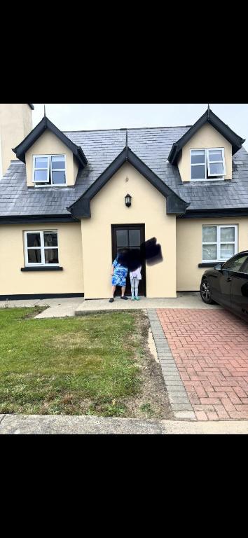 a house with a dog standing in front of it at Golf central in Rosslare Harbour