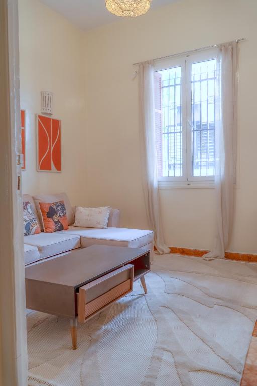 a living room with two beds and two windows at COZY APPARTEMENT Center city 11 janvier in Casablanca