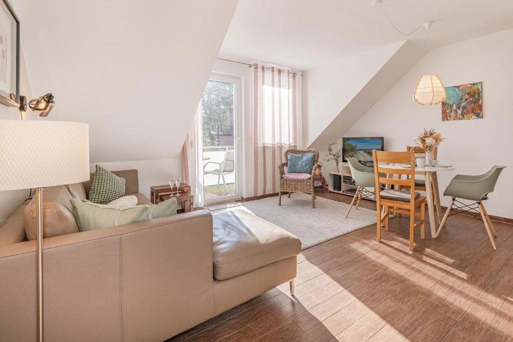 a living room with a couch and a table at FeWo Dünengrün in Trassenheide