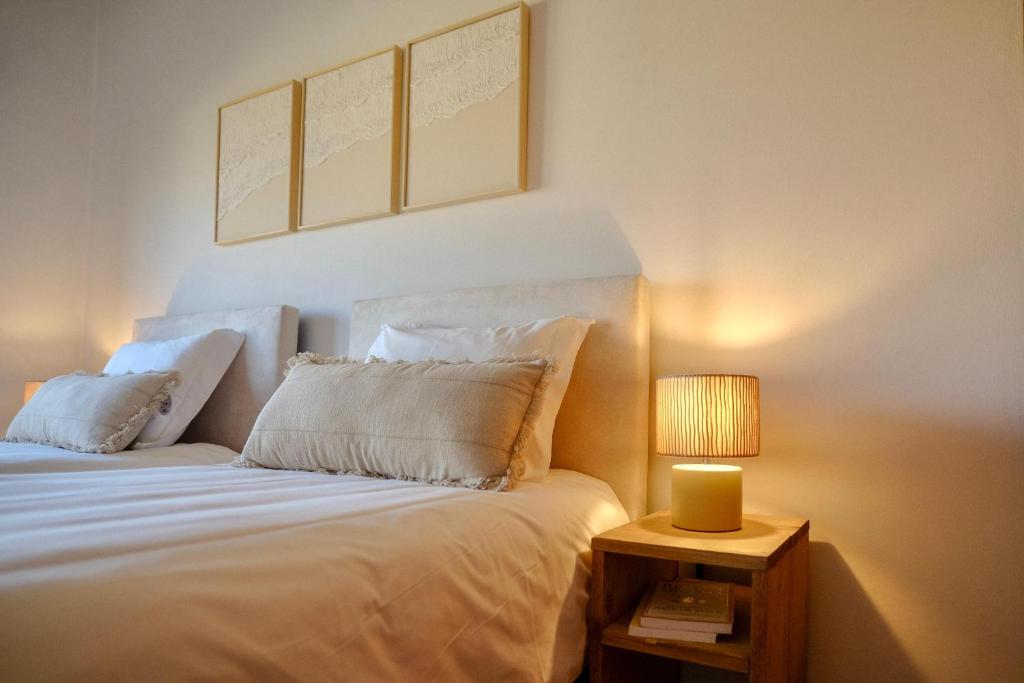 a bedroom with a white bed with a lamp on a table at Step by Step Atlantic Guesthouse in Vila do Conde