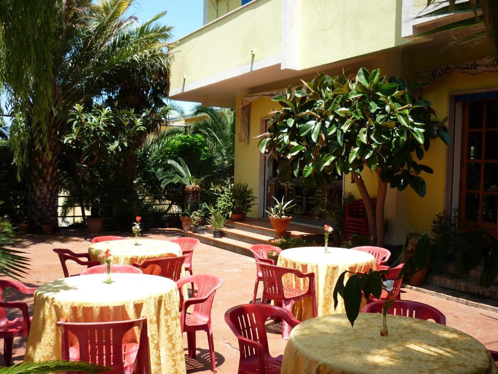 eine Gruppe von Tischen und Stühlen im Innenhof in der Unterkunft Hotel Alexander in Tropea