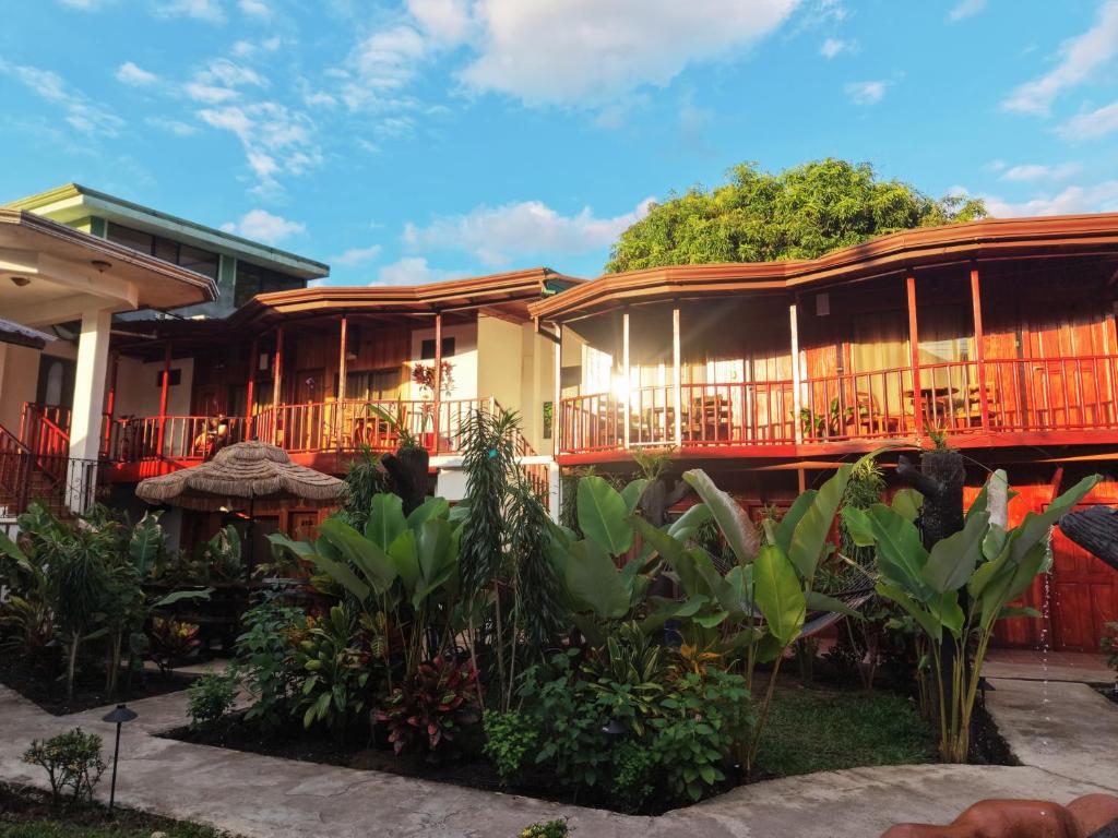 a resort with a lot of plants in front of it at Poshtel Arenal in Fortuna