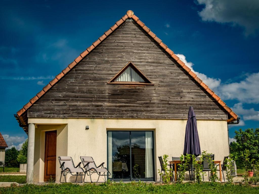 a house with a group of chairs and an umbrella at Lac Bleu 16 in Lacapelle-Marival