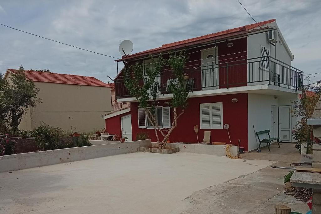 a red and white house with a balcony at Apartments with parking space Slatine, Ciovo - 16732 in Slatine