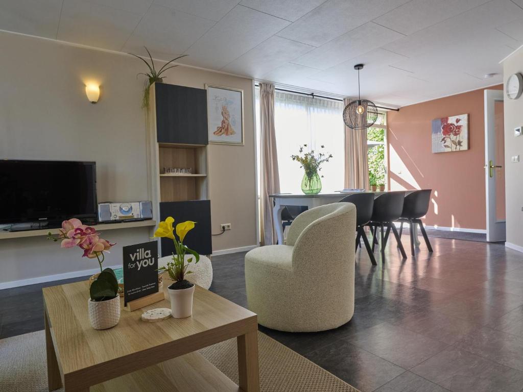 a living room with a table and a dining room at Scheldeoord 54 in Baarland