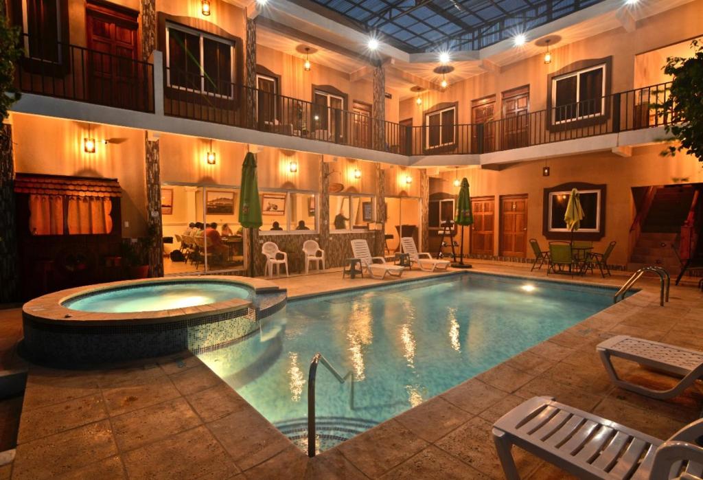 a large swimming pool in a large building at Maximos Petit Hotel in Flores