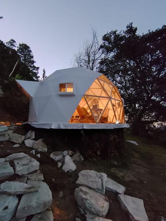 a dome house with a window on top of a pile of rocks at Glamping Entre las Nubes in Mineral del Monte
