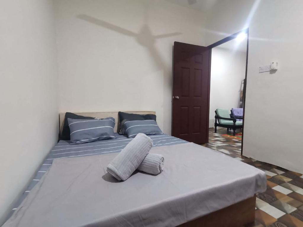 a bedroom with a large bed with two pillows on it at BLISS HomeStay in Sipitang